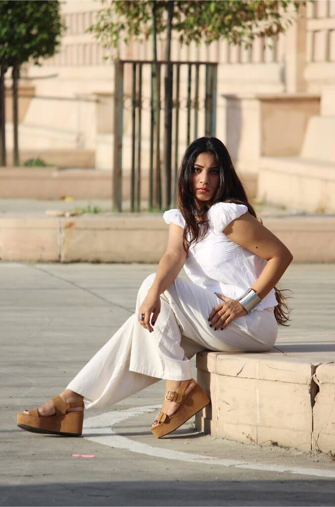 Model Sitting In Chikankari Dress Wearing big silver bracelet in hands